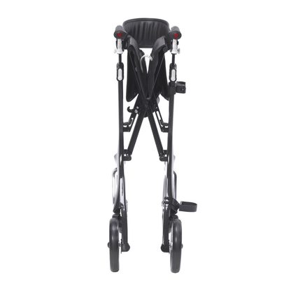 The Drive Nitro® Elite CF Carbon Fiber Rollator, shown from the front in its folded position, features a black frame with dual pairs of wheels and a visible seat.