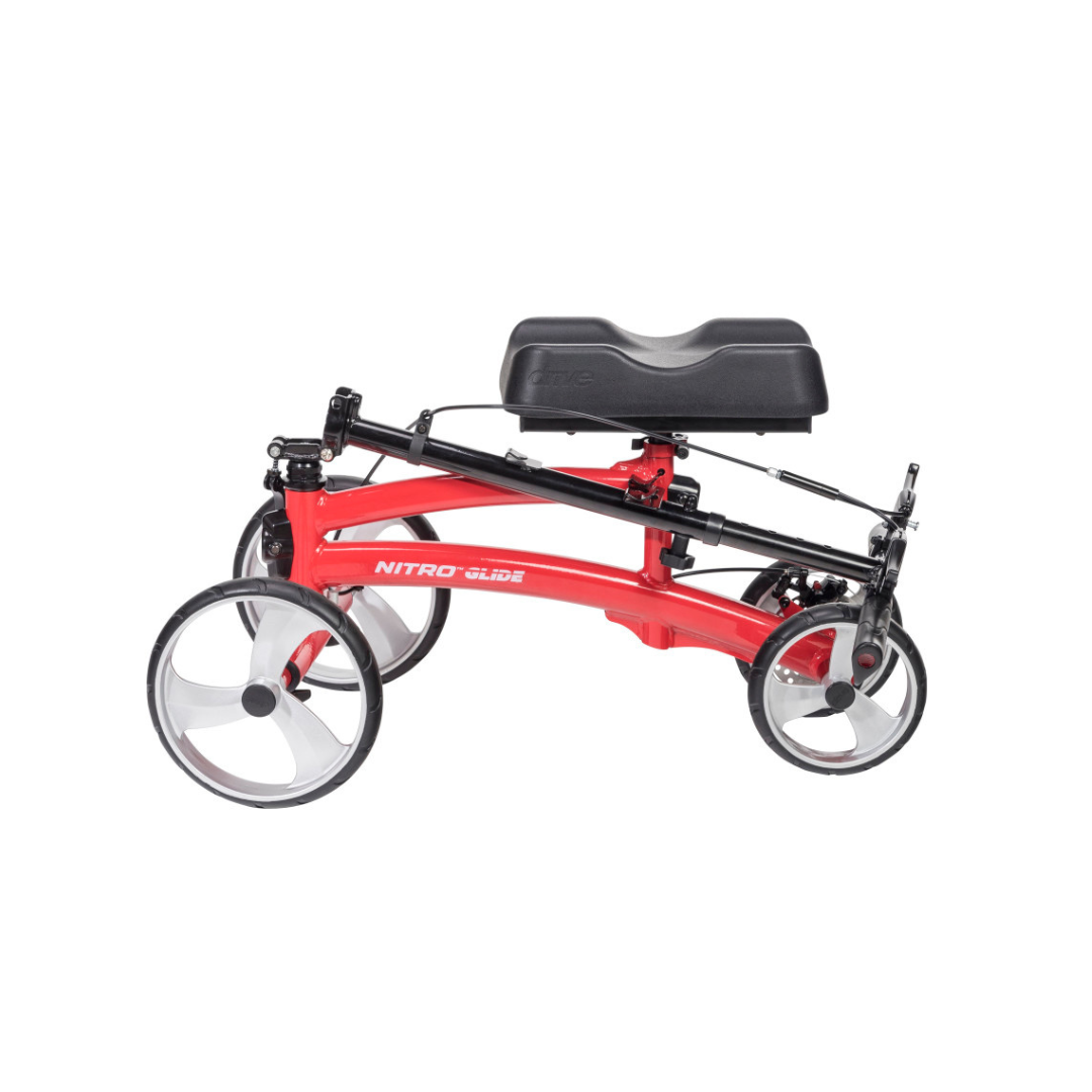 The Drive Folding Nitro® Glide Knee Walker is a red scooter with black padding and large clear wheels, offering sturdy support as a reliable mobility aid and crutch alternative. "NITRO GLIDE" is labeled on the side.