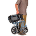 Man holding the Nova Medical Lightweight Transport Chair with Locking Hand Brakes an XL Wheels Blue 352B