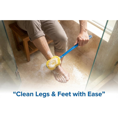 A person sits in the shower on a bench, using the Nova 23” Extra Long Bath & Back Sponge Brush (2 Pack) with soap to easily clean their lower leg and foot. Text at the bottom reads: Clean Legs & Feet with Ease.