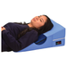 A woman lies on her back, head and upper body elevated on the Nova Bed Wedge for Back & Side Sleepers with Half Roll Pillow Insert (2 Pack), which features a soft cover and a small nova logo on the side.