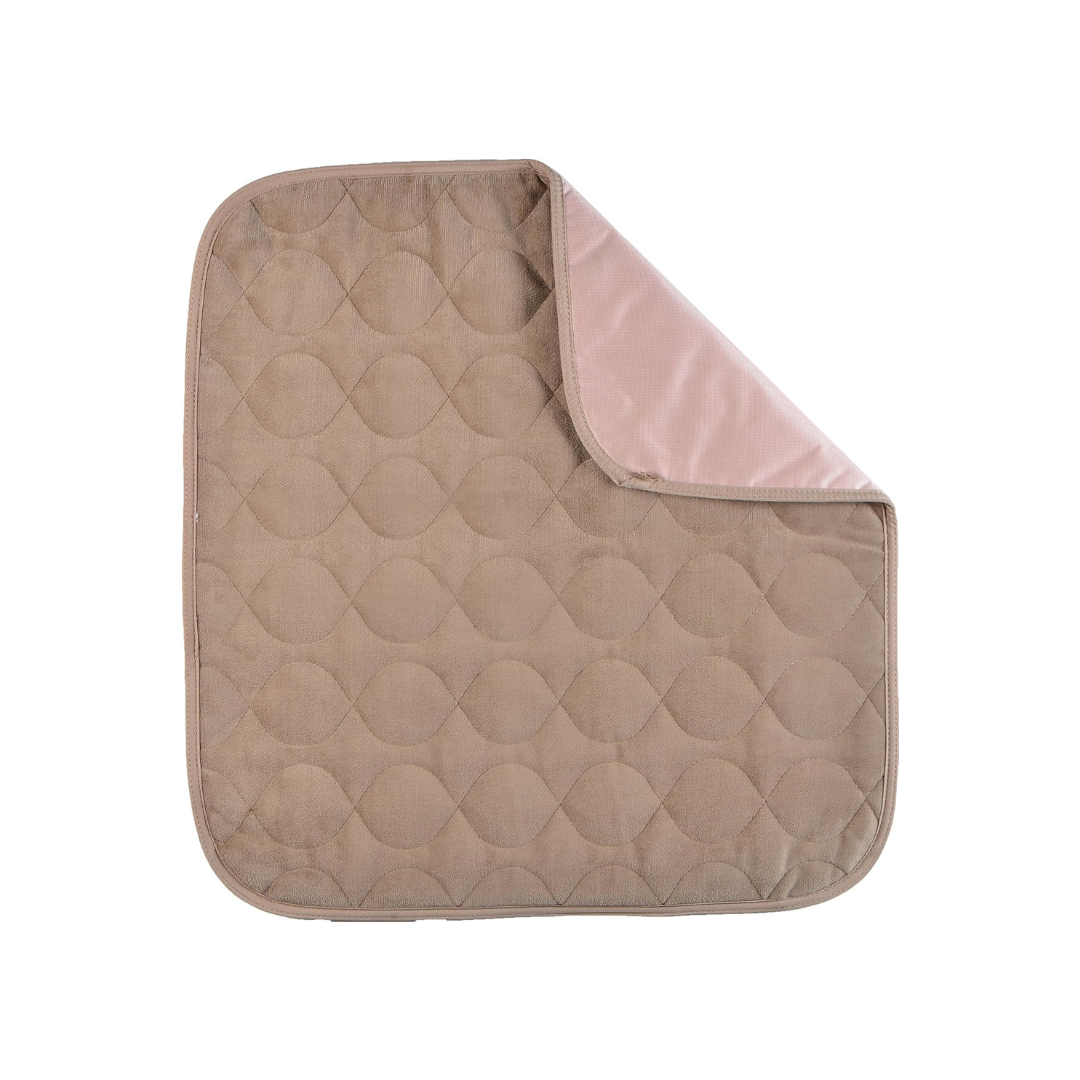 The Nova Ultra Reusable Waterproof Underpad For Chairs (21" x 22") is a quilted, square, beige pad with rounded corners and a light pink underside, shown partially folded on a white background.