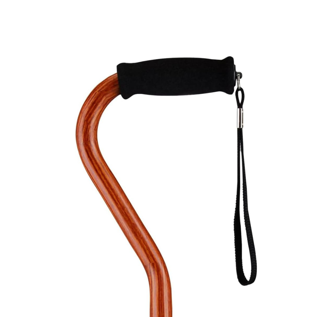 A close-up of the handle of a Nova Designer Offset Walking Cane, featuring a black foam grip and attached black wrist strap, set against a plain white background.