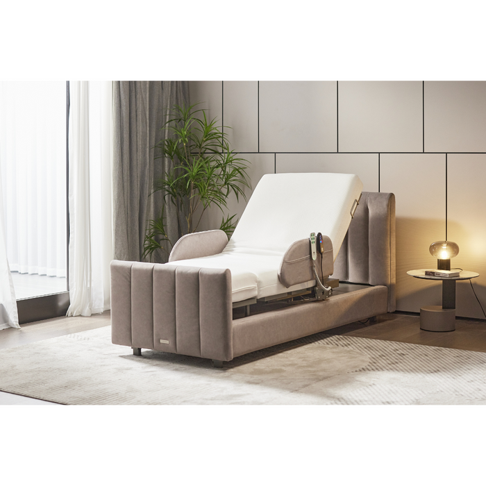 The Starsleep Orin Rotating Full Electric Lift Assist Bed with Heat & Massage, beige upholstered and elevated headrest, sits in a modern room on plush carpet near a round table with a lamp by sheer-curtain windows and a tall plant.