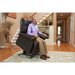 An older man relaxes in a Golden Tech PR510 MaxiComfort Cloud Recliner with Lift Assist - Extra Wide featuring Zero Gravity+ positioning, slightly elevated in a cozy living room. Decorative plants are behind him on wooden floors with a patterned rug, as he holds the remote.