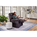 In a bright living room, a woman relaxes in a Golden Tech PR510 MaxiComfort Cloud Recliner with Lift Assist - Extra Wide, holding a tablet. The Zero Gravity+ (ZG+) setting boosts her comfort as she enjoys the large windows, potted plant, white ottoman, and art-adorned cabinet in the cozy space.