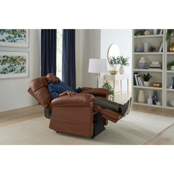 Someone is relaxing in a fully reclined Golden Tech PR515 Cloud Recliner with Lift Assist, ZG+ & Twilight - SM/MD, enjoying ergonomic support. Theyre in a modern living room with navy curtains, framed artworks, a round mirror, and shelves displaying decor. Their eyes are gently closed.