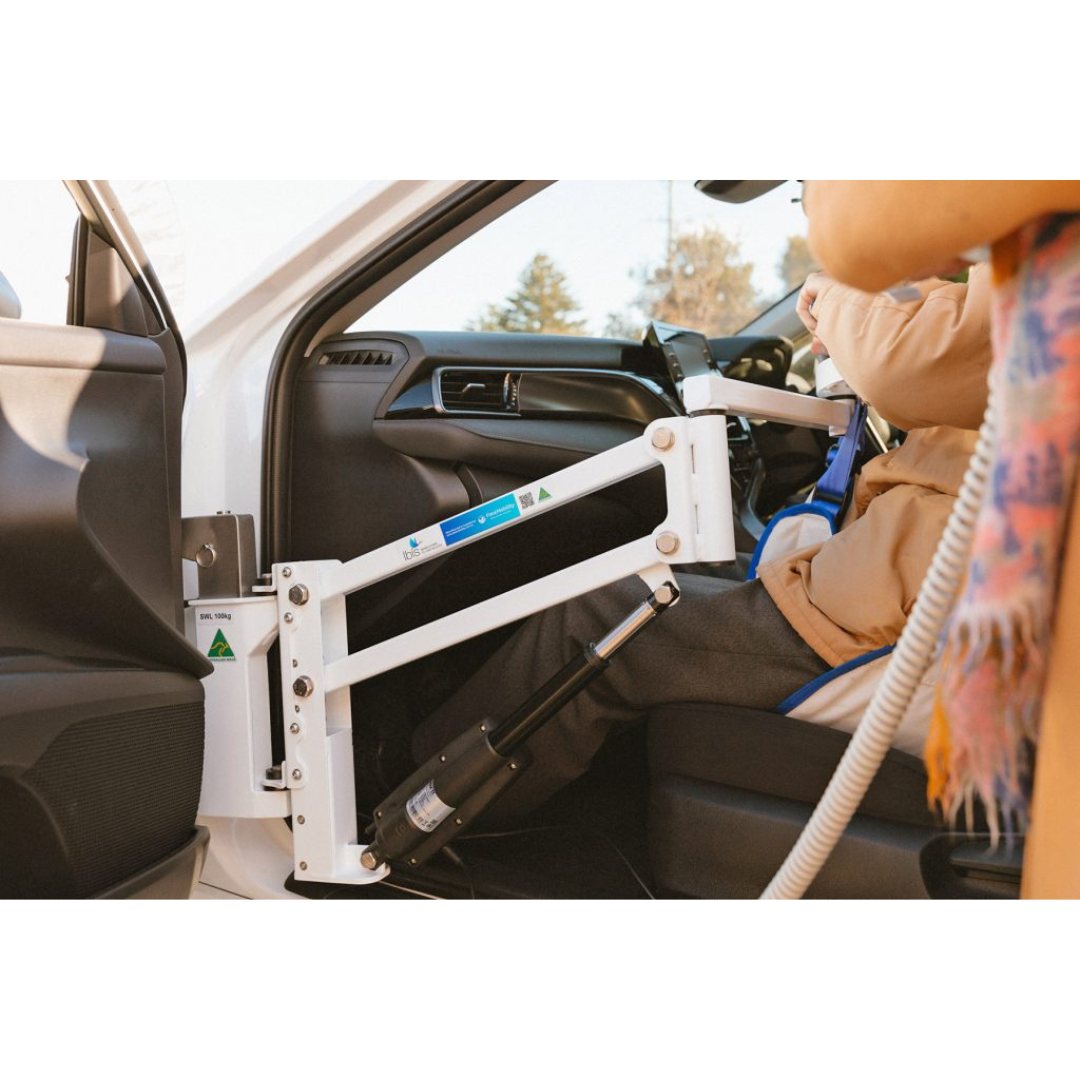 A person uses the Para Mobility IBIS Wheelchair to Car Access Lift from the passenger side, showcasing an accessible solution for transferring from a wheelchair into a vehicle.