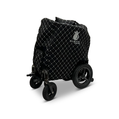 A ComfyGo Phoenix Electric Wheelchair Travel Bag & Protector Set, featuring a quilted black durable canvas cover with a white Majestic logo, is displayed folded against a plain white background.