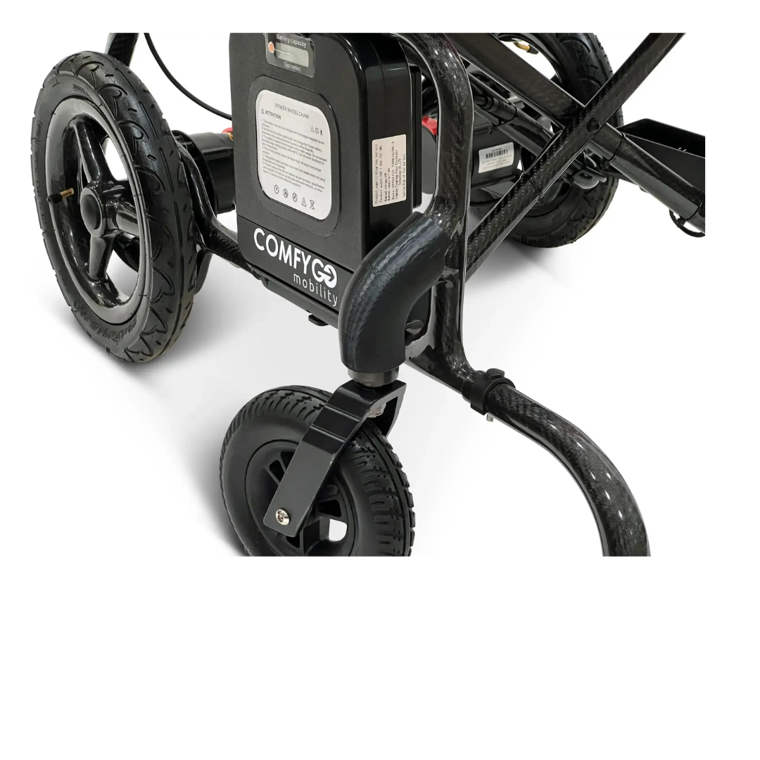 Close-up of the rear wheels and battery compartment of a black ComfyGo Phoenix Electric Wheelchair, with the label and frame visible, alongside the ComfyGo Phoenix Electric Wheelchair Travel Bag & Protector Set made from durable canvas against a white background.
