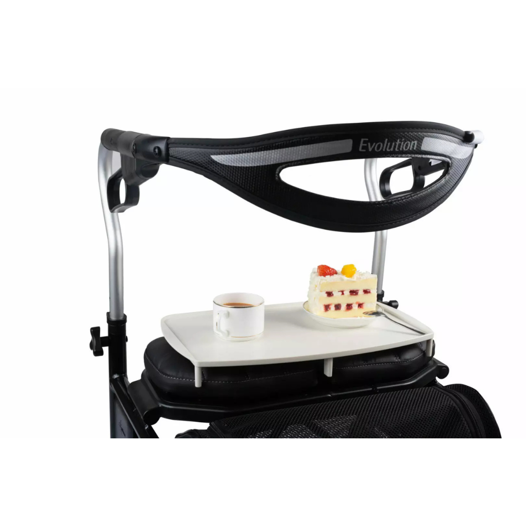 A close-up of the Plastic Food & Drink Tray for Evolution Rollators holds a cup of coffee and layered fruit-topped cake, attached to the walker’s black Evolution handle—an ideal accessory for carrying refreshments.
