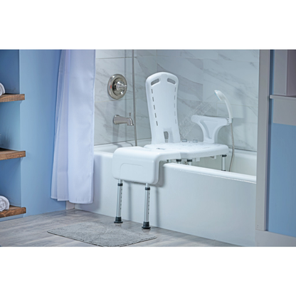 The bathroom features light blue walls, a gray bath mat, shelves with rolled towels, and the Drive PreserveTech™ Aquachair Bathing System with Bidet—a white shower chair with adjustable legs for independent bathing across the tub.