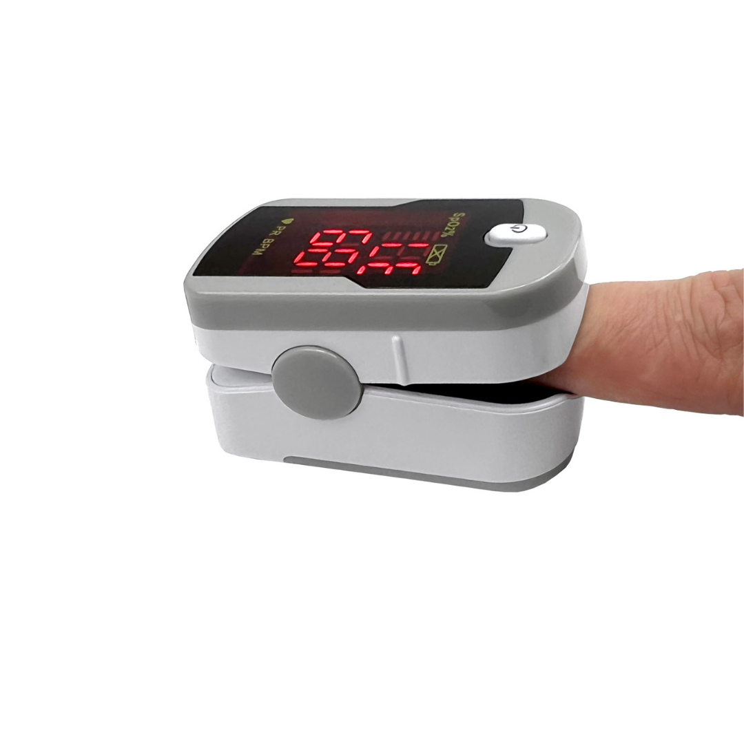 A close-up of the Prestige Medical Deluxe Fingertip Pulse Oximeter clipped on a finger, showing oxygen saturation and pulse rate on a red LED screen. The device is gray and white.