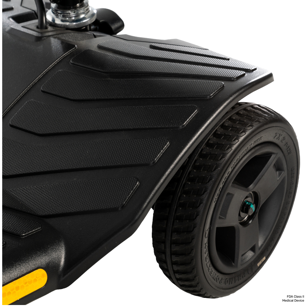 Close-up of the textured footrest platform and large wheel with visible tread details on a black Pride Go Go® Ultra X Gen 3 Portable Mobility Scooter, highlighting its sturdy and modern design.