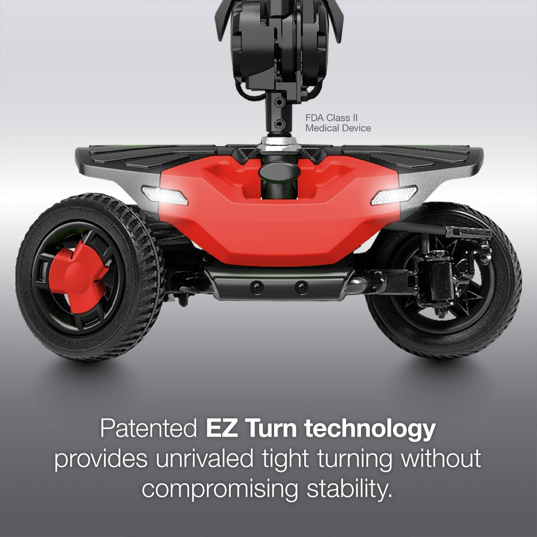 Close-up front view of a red three-wheeled Pride Go Go® Elite Traveller Gen 3 Platinum Portable Scooter base, labeled as an FDA Class II Medical Device with patented EZ Turn technology for stability.