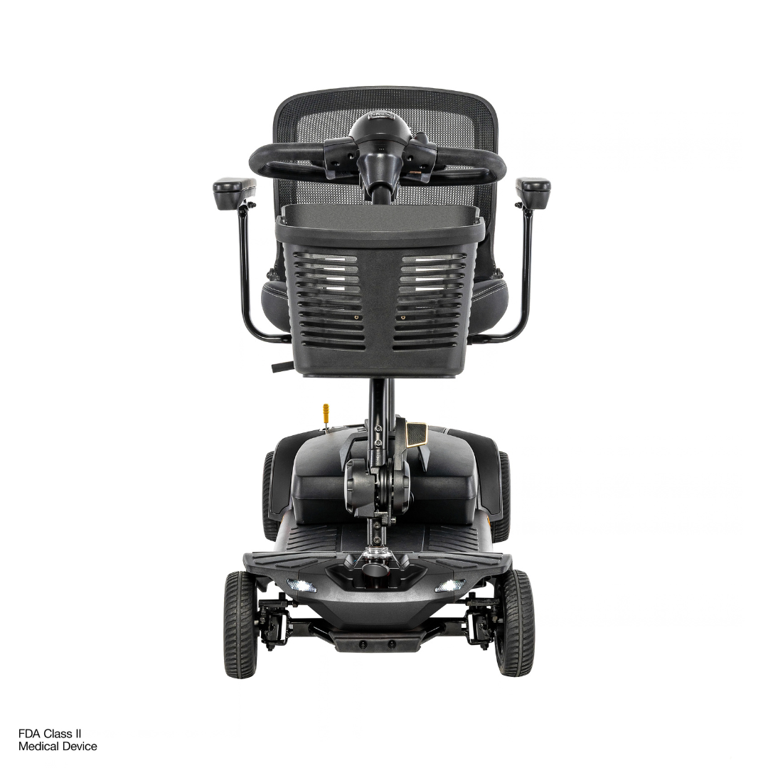 A front view of the Pride Go Go® Elite Traveller Gen 3 Platinum Portable Scooter, a four-wheeled mobility scooter featuring a black mesh seat, handlebars, and a front-mounted storage basket.