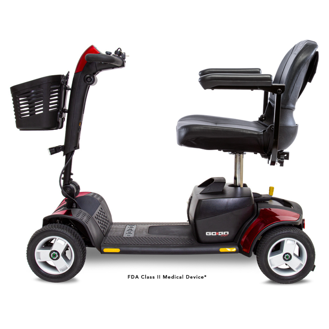 Side view of the Pride Go Go® Sport 4-Wheel Scooter, in red and black, with four wheels, a padded seat with armrests, a control handle, and a front basket. This FDA Class II Medical Device offers feather-touch disassembly for easy transport.