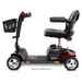 Side view of the Pride Go Go® Sport 4-Wheel Scooter, in red and black, with four wheels, a padded seat with armrests, a control handle, and a front basket. This FDA Class II Medical Device offers feather-touch disassembly for easy transport.