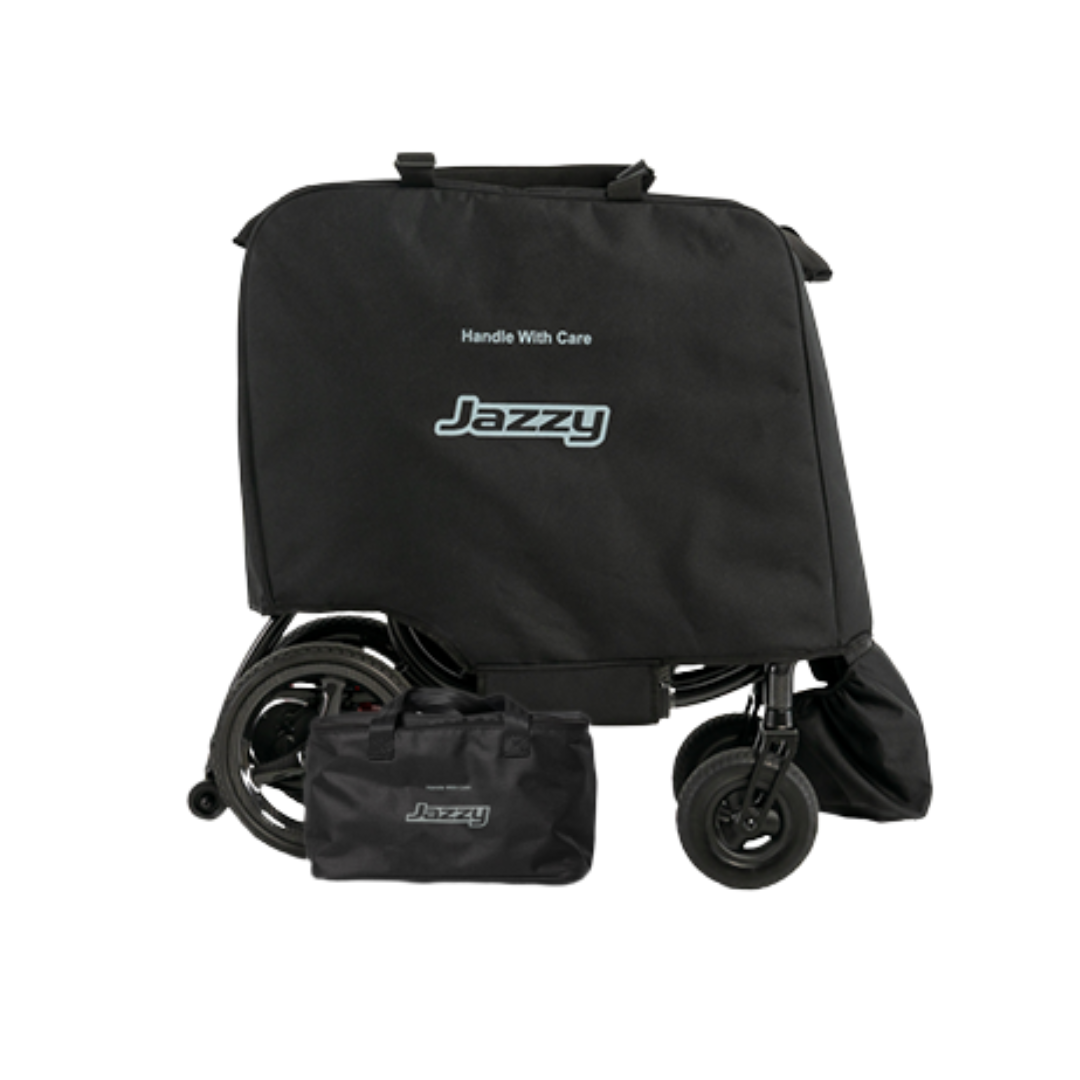 A black Jazzy®-branded cover protects folded Accessories for the Jazzy® Carbon 27X Powerchair, ideal for storing lightweight items. A matching smaller bag shows the logo, and "Handle With Care" is printed on the cover.
