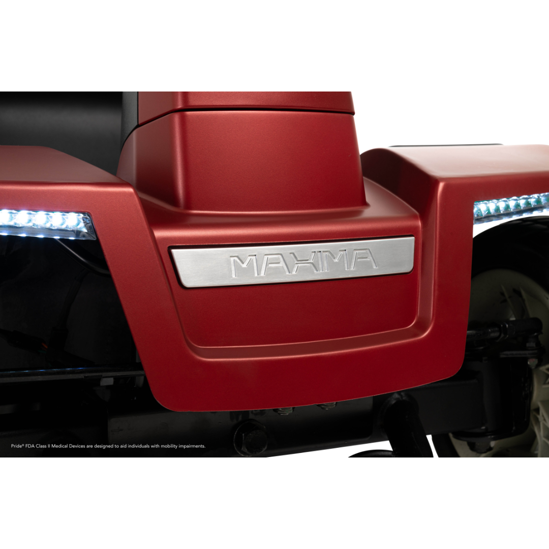 Close-up of the Pride Mobility Maxima 4-Wheel Bariatric Scooter’s red front, featuring a silver “MAXIMA” plate and LED lighting package on both sides.