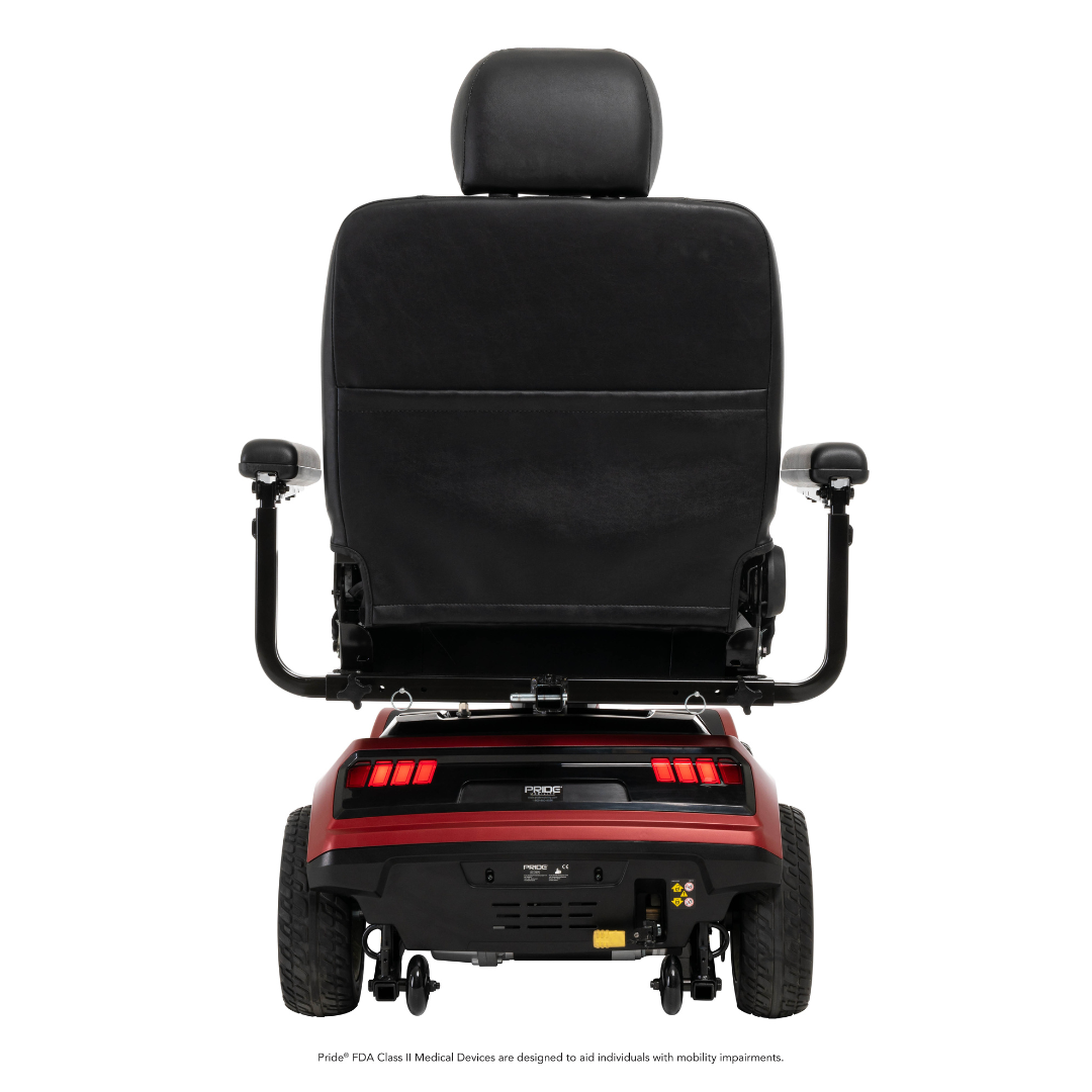 A rear view of the Pride Mobility Maxima 4-Wheel Bariatric Scooter in black and red, featuring large wheels, two armrests, a high backrest, visible control panel, brake lights, and integrated LED lighting for enhanced safety.