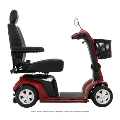 The Pride Mobility Maxima 4-Wheel Bariatric Scooter, in red and black, features a padded seat, armrests, basket, side mirror, and LED lighting package; side view shown against a white background.
