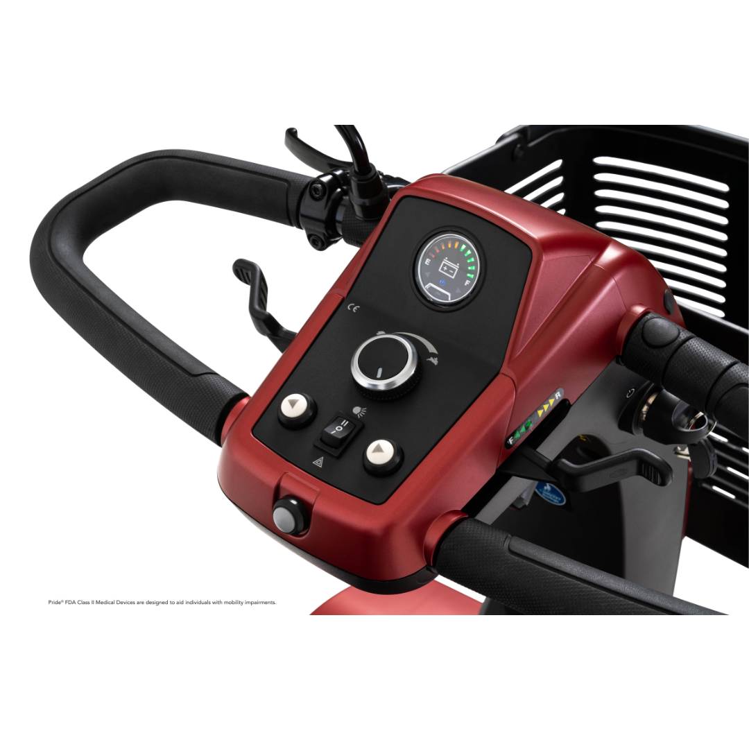 Close-up of the control panel and handlebars on the Pride Mobility Maxima 4-Wheel Bariatric Scooter in red, featuring a display screen, control knobs, buttons, black wire basket, and an LED lighting package.