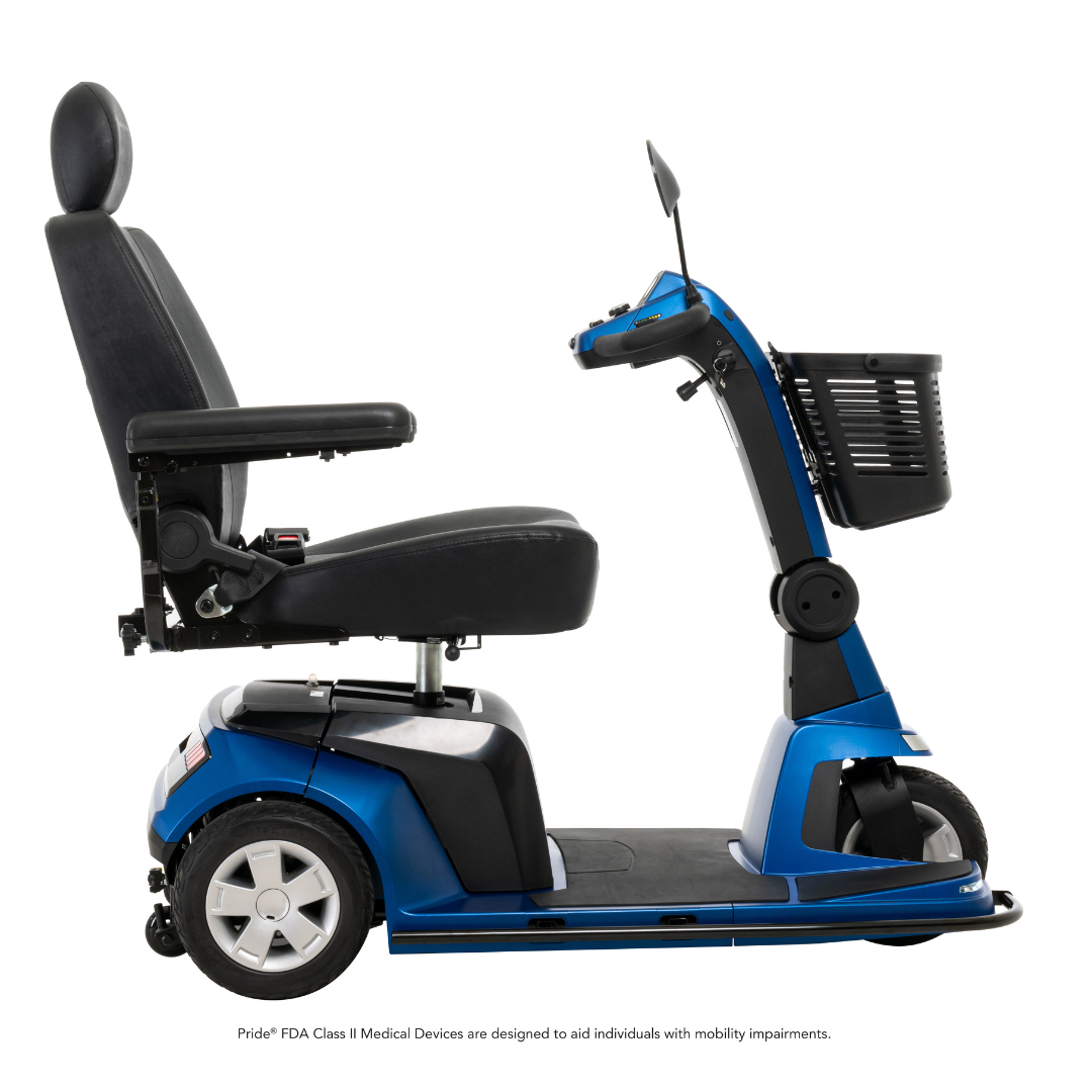 The Pride Mobility Maxima 3-Wheel Bariatric Scooter, shown in blue with a high back seat, armrests, handlebar controls, and front basket, is displayed from the side on a white background and supports up to 500 lbs.