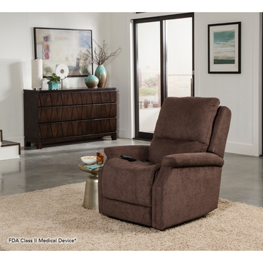 A Pride VivaLift! Metro 2 Recliner with Lift Assist, upholstered in brown, is in a modern living room with a dresser, décor, two framed artworks, and a glass door. A remote rests on the chair's arm.