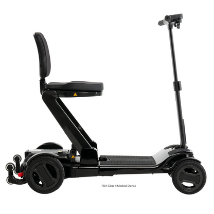 Side view of the Pride Mobility GoGo Carbon Ultralite Mobility Scooter, a black foldable electric model with four wheels and a seat. This 35 lbs lightweight scooter features adjustable handlebars and a padded seat for comfort, with a durable carbon fiber frame for easy transport.