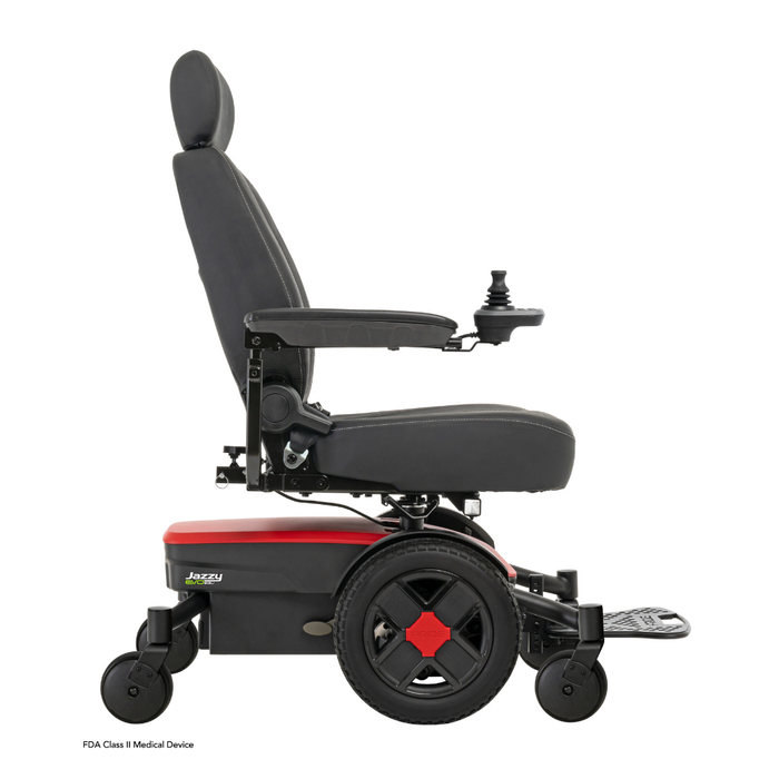 A side view of the black and red Pride Mobility Jazzy® EVO 613 Powerchair with ATX Suspension, featuring a padded seat, armrests, headrest, joystick control, large rear wheels, small front wheels, and Mid-Wheel 6® Technology for superior maneuverability.