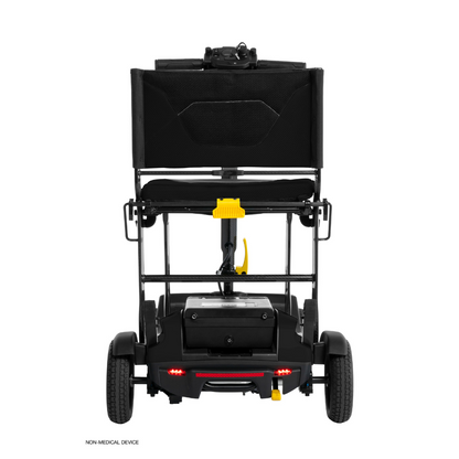 Rear view of a black Pride Mobility Go Go® Super Portable Mobility Scooter with foldable seatback, small wheels, and a yellow lever beneath the seat. This scooter has a compact design, lightweight frame, airline-approved battery, and non-medical device label on the bottom left.