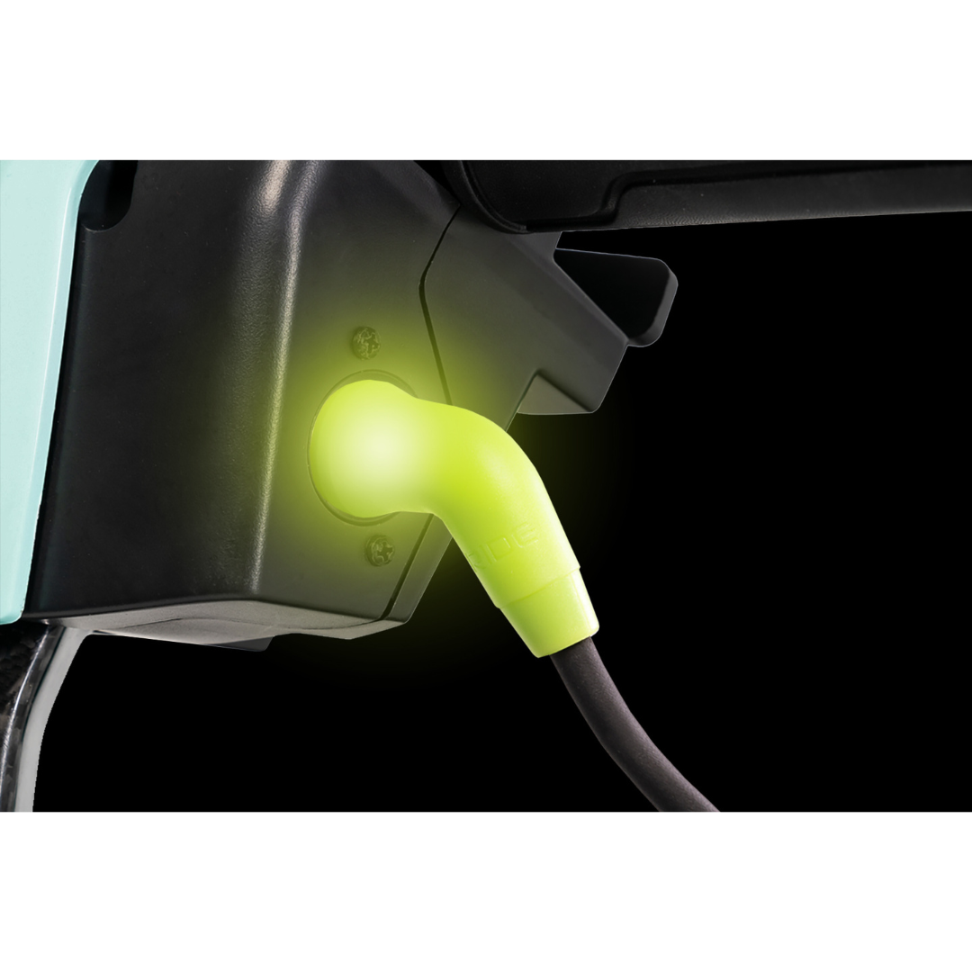A glowing green cable plugged into an EV charging port stands out against the black background, reminiscent of the seamless efficiency of the Pride Mobility Go Go® Super Portable Scooters airline-approved battery.