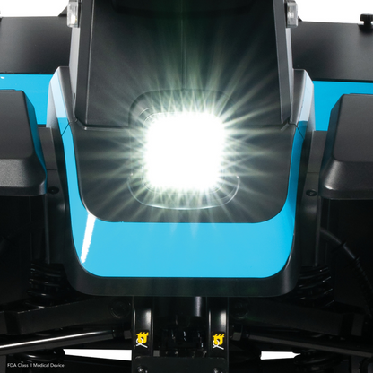 Close-up of the bright white headlight on a blue and black Pride Mobility PX4 HD Bariatric Scooter, with radiant light flares visible from the center.