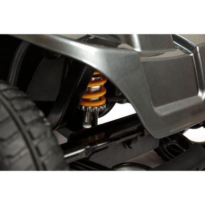 Close-up of the Pride Mobility Revo® 2.0 4-Wheel Scooter’s suspension, featuring a yellow coil spring, wheel, and fender, showcasing its sturdy build and detailed mechanical design.