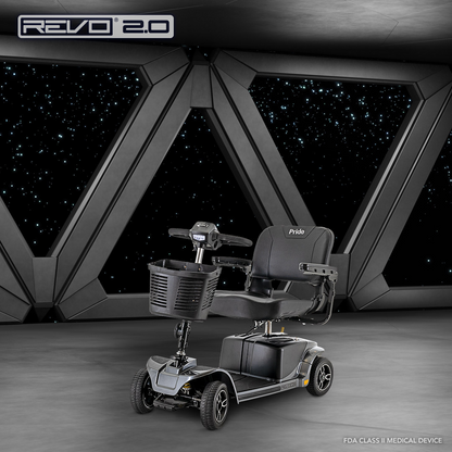 A black Pride Mobility Revo® 2.0 4-Wheel Scooter is displayed in a futuristic room with large geometric windows overlooking a starry night. The scooter includes a front basket, armrests, and is ready for use.