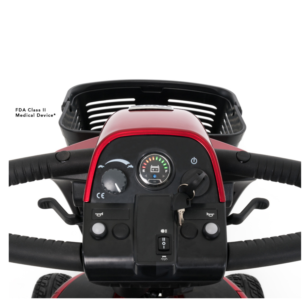 Close-up of the control panel on a Pride Mobility Victory® 10.2 Bariatric 3-Wheel Scooter, featuring handlebars, ignition key, buttons, battery indicator, display, rear black basket, and a medical device label on the left side.