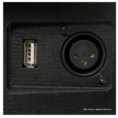 Close-up of the black control panel on a Pride Mobility Victory® 10.2 Bariatric 3-Wheel Scooter, showing a USB port on the left and a three-pin circular XLR connector on the right, with textured finish and visible small screws.