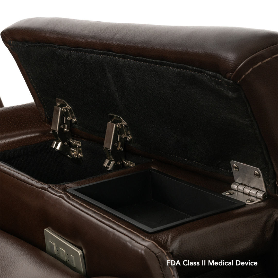 A close-up of an open storage compartment in the armrest of a brown leather Pride VivaLift! Premier Recliner With Assisted Lift, Audio & Massage. The black-lined compartment has metal hinges. "FDA Class II Medical Device" is in the bottom right corner.