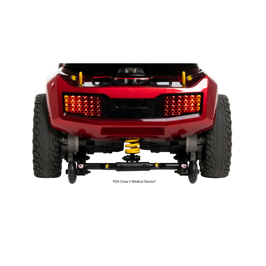 Rear view of a red Pride Mobility Zero Turn 10 HD Scooter with large tires, yellow spring suspension, and rectangular red brake lights. Text below indicates FDA Class II Medical Device.