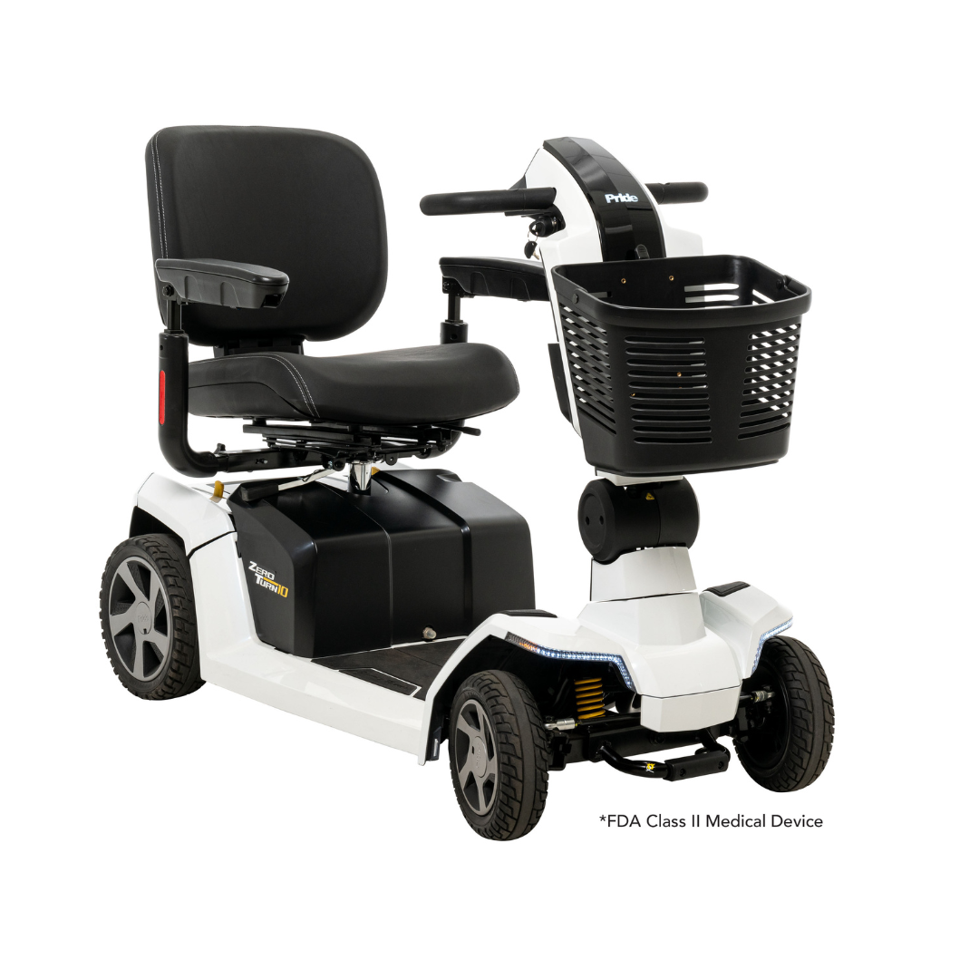 The Pride Mobility Zero Turn 10 HD Scooter is a white, four-wheel midsize scooter with a black cushioned seat, armrests, backrest, front control panel, and front storage basket. It is an FDA Class II Medical Device for added safety.