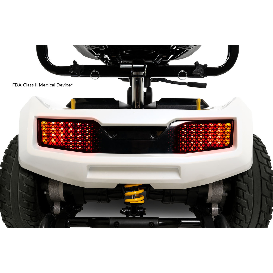 Rear view of the Pride Mobility Zero Turn 10 HD Scooter displaying illuminated red tail lights, large tires, a white bumper, and visible suspension components.