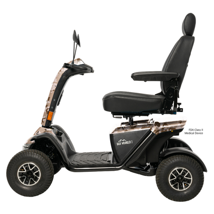 A side view of the Pride Baja® Wrangler® 2 Heavy Duty Outdoor Scooter, a black four-wheeled all-terrain scooter with a large padded seat, armrests, rugged tires, light camo accents, and advanced safety features.