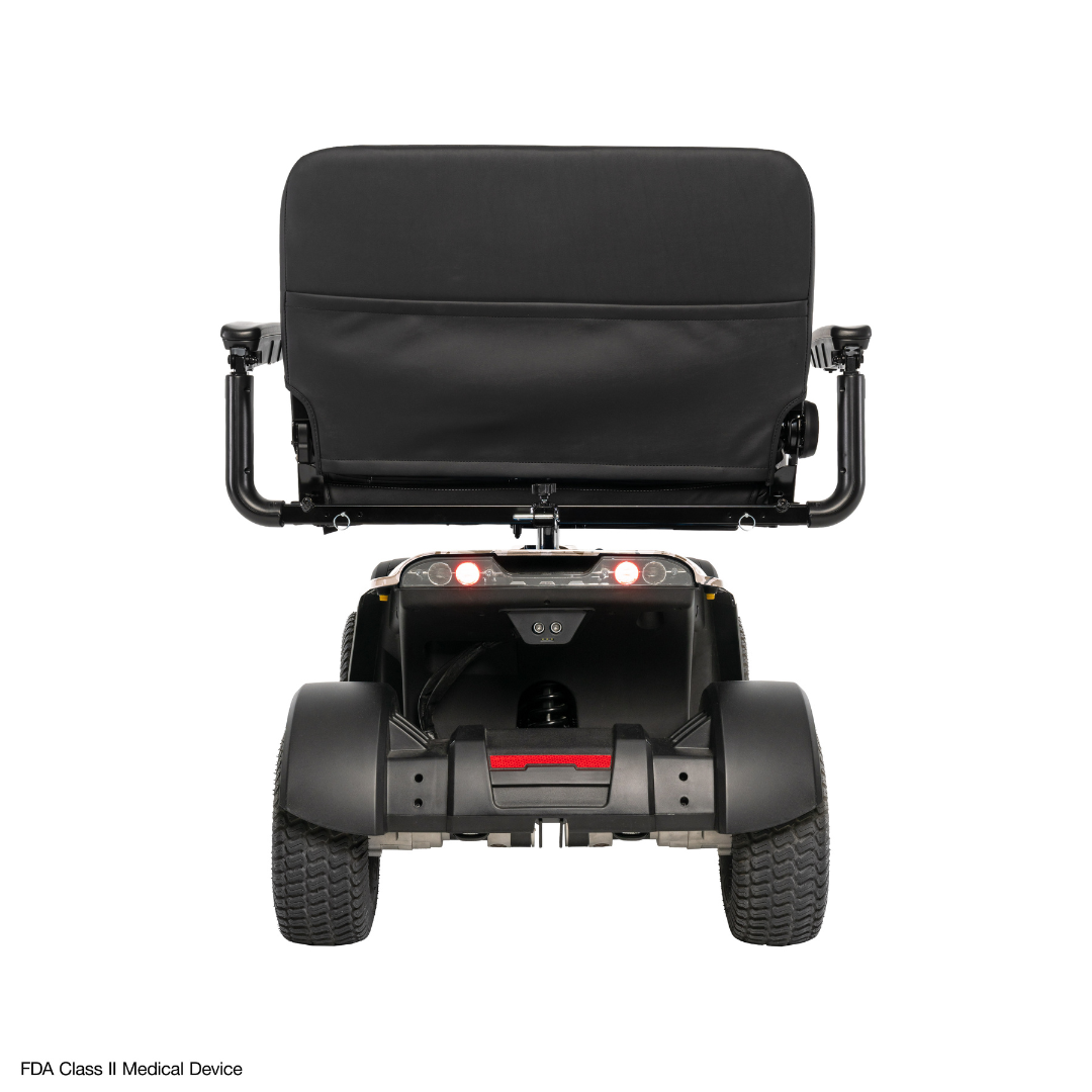 Rear view of the Pride Baja® Wrangler® 2 Heavy Duty Outdoor Scooter with black cushioned seat, armrests, wide tires, and two red rear lights on a plain white background. Lower left text: FDA Class II Medical Device.