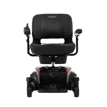 Front view of the Pride Mobility Go Chair® Portable Powerchair in black and red, featuring a padded seat, armrests, left-side joystick control, small wheels, compact turning radius, and Pride branding on the backrest.