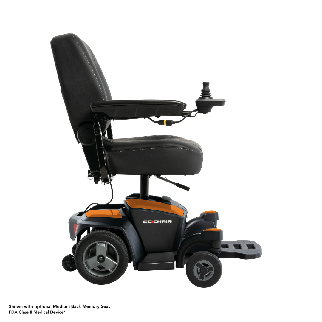 A side view of the black and orange Pride Mobility Go Chair® Portable Powerchair, featuring joystick control on the armrest. The raised seat and extended footrest are shown, highlighting its compact turning radius for easy maneuvering. White background.