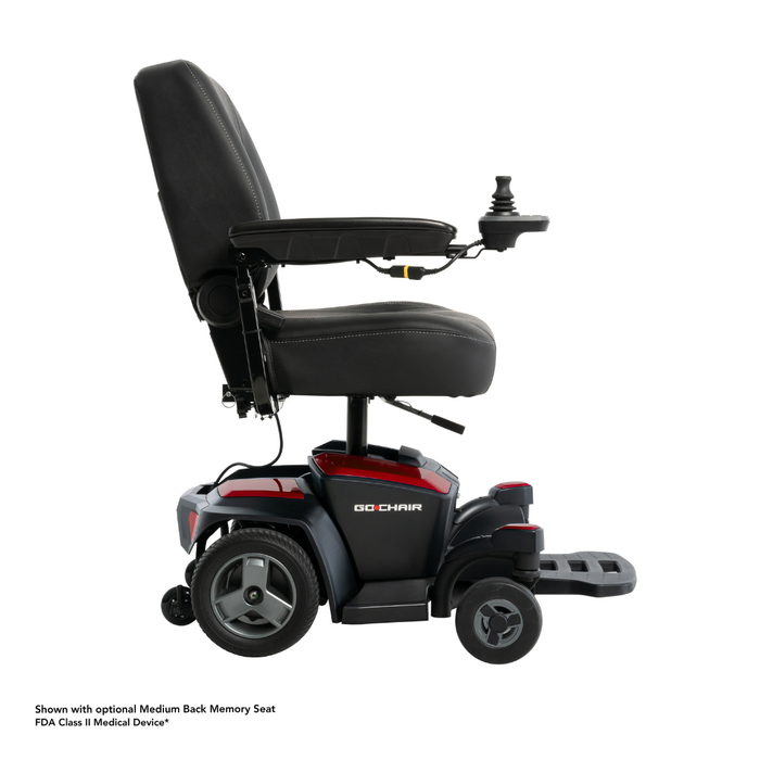 The Pride Mobility Go Chair® Portable Powerchair, shown in black and red with padded seat, armrests, footrest, large rear wheels, and a joystick controller, is displayed in side view. It offers a compact turning radius for easy maneuverability.