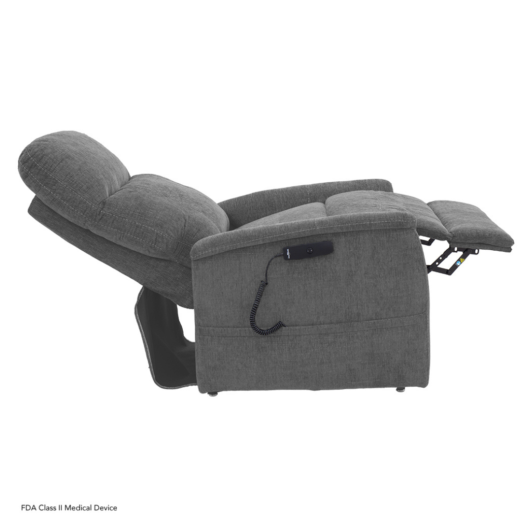 The Pride Mobility Genesis LC150 Lift Chair Recliner is shown fully reclined in gray upholstery, featuring a corded remote control on the side. Check the spec table in the description for full product details.
