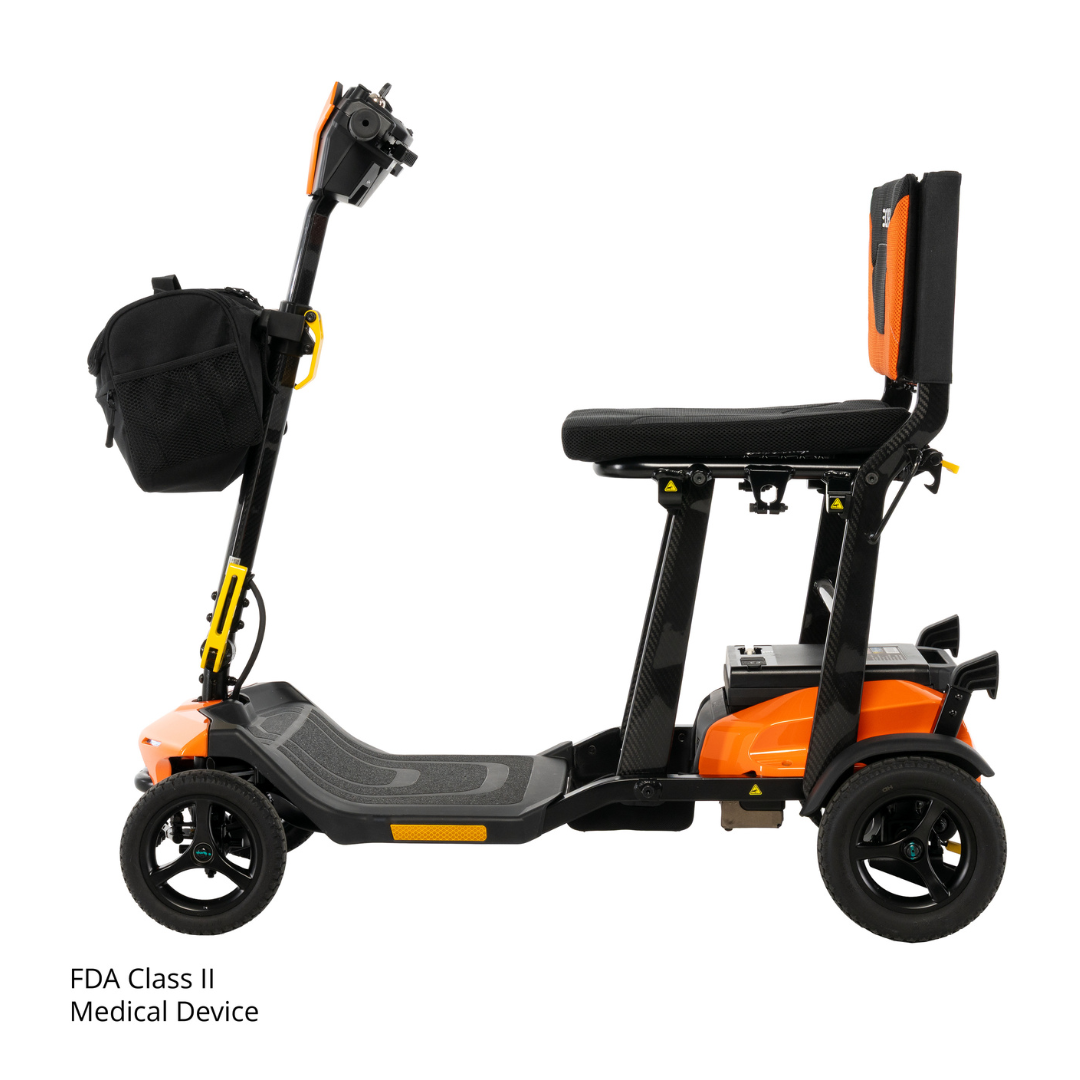 Side view of the Pride Mobility Go Go® Super Portable Mobility Scooter, orange and black, featuring a seat, backrest, handlebars, four wheels, and a front black storage bag. FDA Class II Medical Device text appears in the lower left corner.
