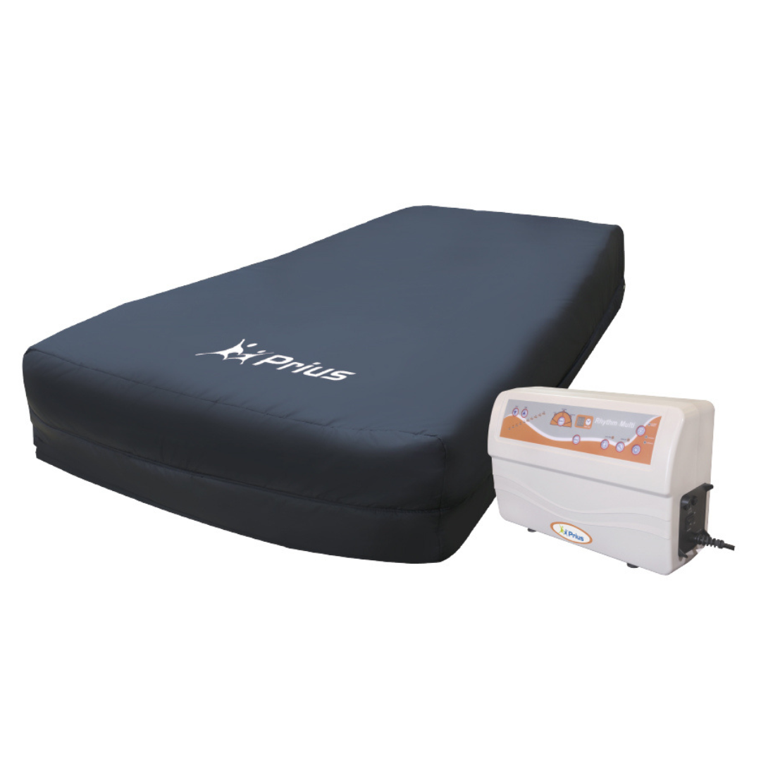 The Prius Rhythm Multi Mattress System, with a 1,000 lb capacity, features a dark fabric cover with the prius logo and includes a control unit for precise adjustments. This advanced therapy solution enhances comfort and support, especially for bariatric patients.
